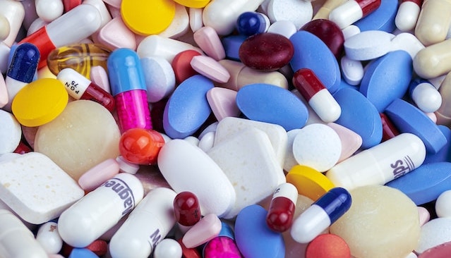 stapel verschillend gekleurde farmaceutische medicijnen en pillen