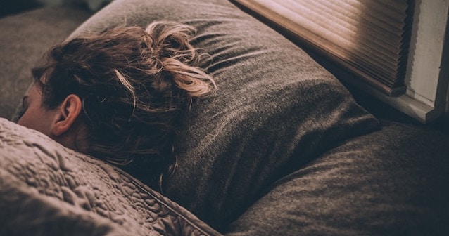 takaróban alvó nő